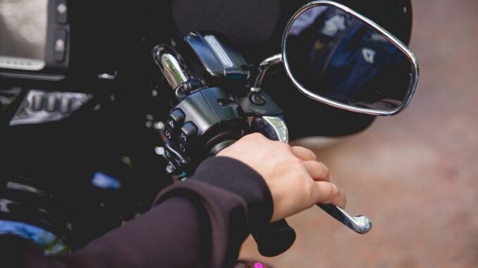 Gros plan main d’un homme tenant le frein manuel et arrêtant de courir concept de sécurité motocycle sur la route